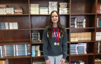 HCMS student displays her medals from District Governor's Cup competition.